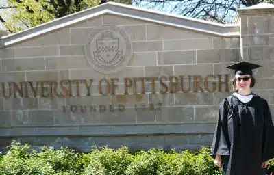 Alex standing in front of partner University of Pittsburgh