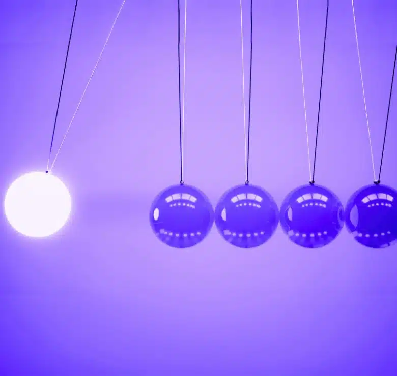 White glowing sphere poised to knock into purple spheres