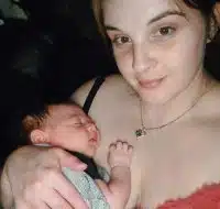 Young mother holds her sleeping newborn son